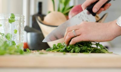 Kniv som skär grönsaker på skärbräda